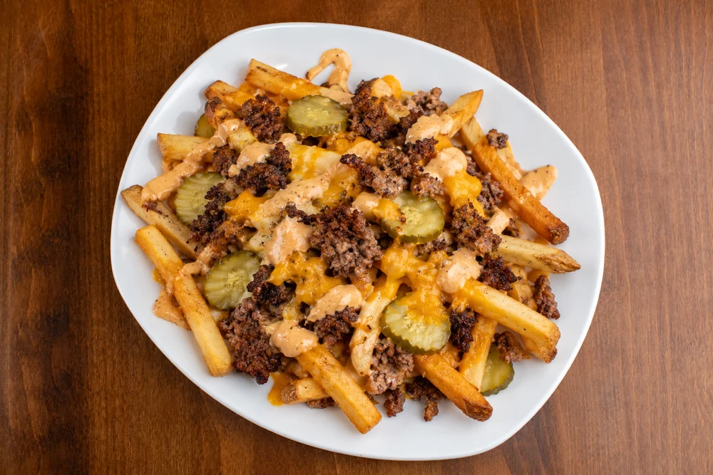 Loaded fries with smashed beef, cheddar, pickles, and house sauce