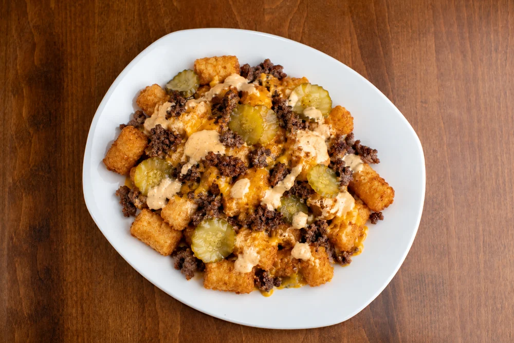 Loaded tots with smashed beef, cheddar, pickles, and house sauce