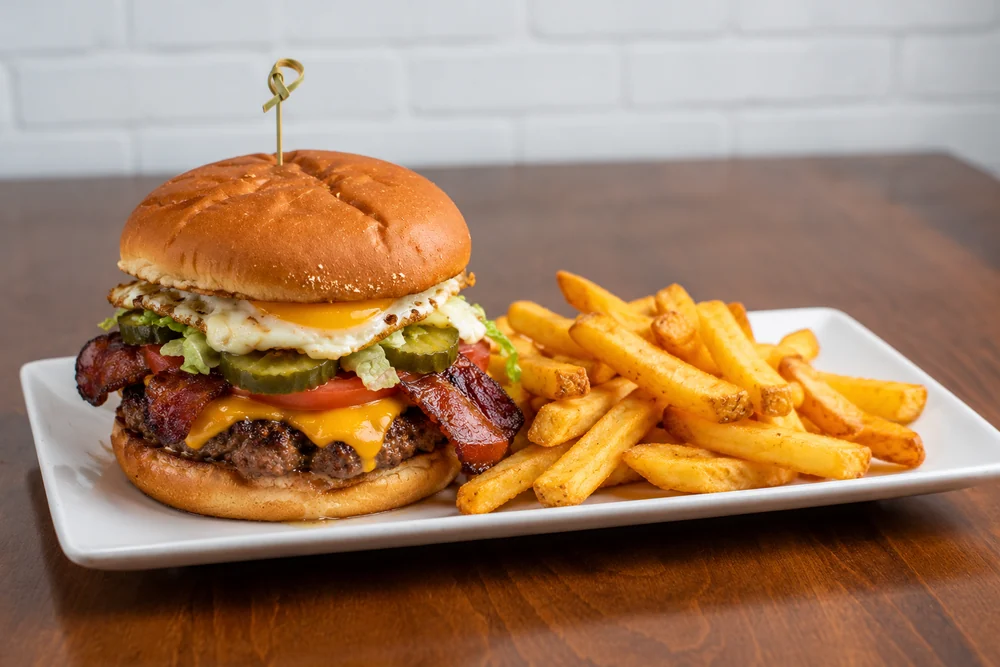 Royal Smash with bacon, lettuce, tomato, pickles, a fried egg, and fries